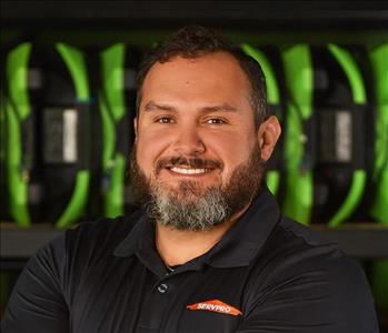 SERVPRO employee in black polo posing for crew photo.