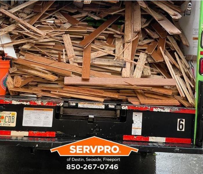 Planks from water-damaged floors are loaded onto a SERVPRO truck.