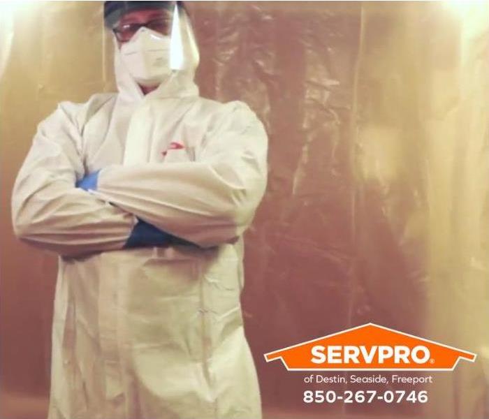 A technician stands inside a mold containment barrier in a home to prevent mold spores from spreading.