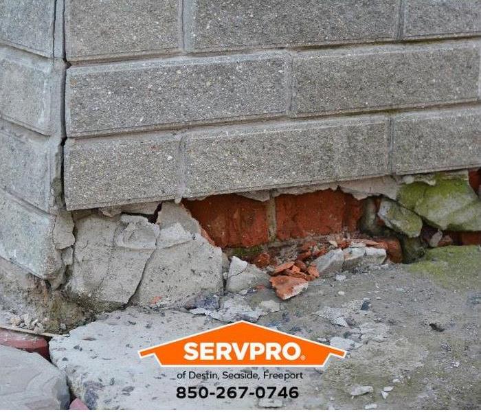A cracked foundation shows water intrusion damage.